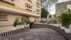 Un patio con una fuente, plantas en macetas y una estatua.