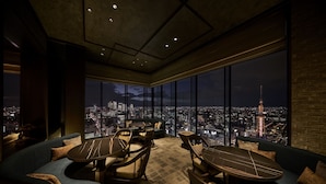 A modern lounge with a city view, featuring a sofa, tables, and chairs. - The Royal Park Hotel Iconic Nagoya (Nagoya)