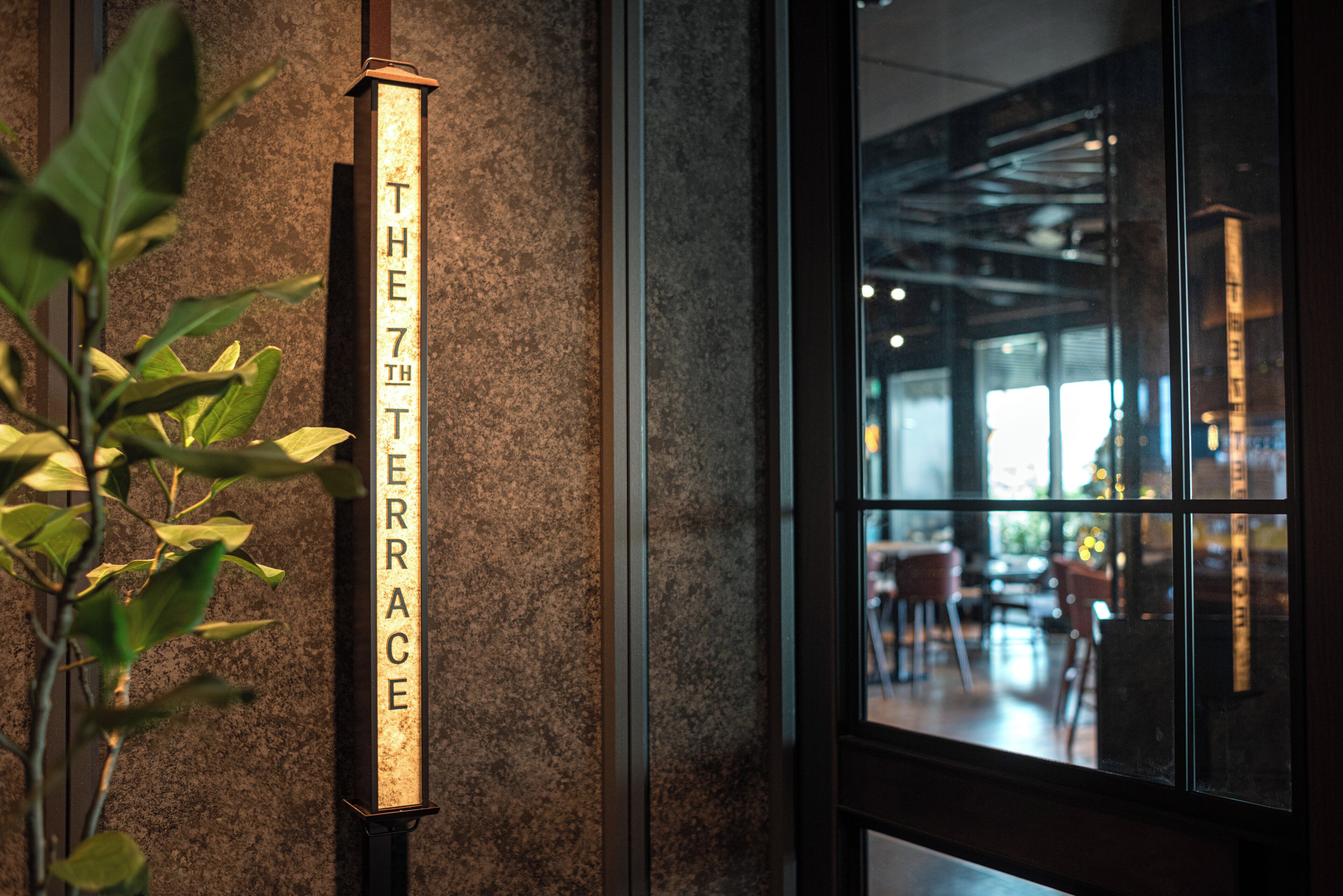 A sign reading "THE 7TH TERRACE" on a textured wall.