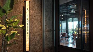 A sign reading "THE 7TH TERRACE" on a textured wall.