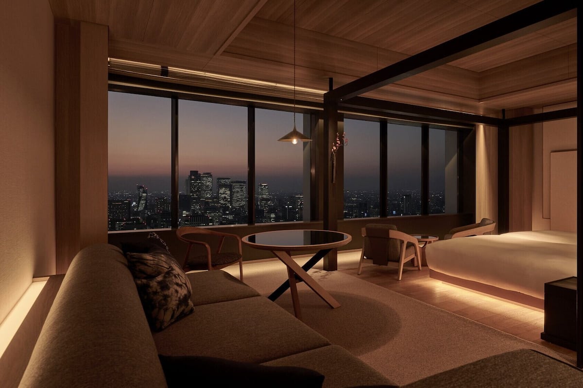 A modern living room with a city view, a round table, and a sofa.