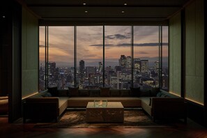 A modern living room with a large window offering a cityscape view. - The Royal Park Hotel Iconic Nagoya (Nagoya)
