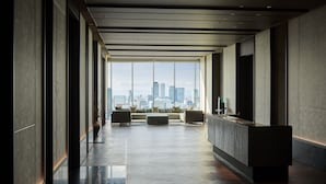 A modern hotel lobby with a long corridor, a reception desk, and a seating area with a city view. - The Royal Park Hotel Iconic Nagoya (Nagoya)