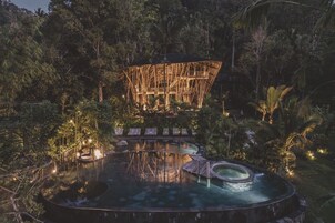 Un área de aguas termales con una estructura de madera y sillas de descanso.