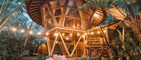 A geodesic dome structure with a circular seating area and a staircase leading to an upper level.