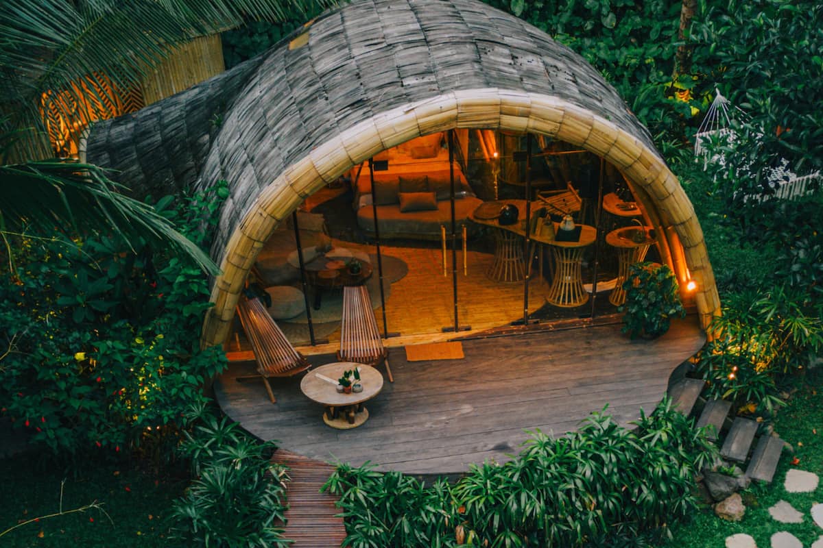 Une structure en forme de dôme, dotée d’une terrasse en bois, d’un espace salon et de tables.