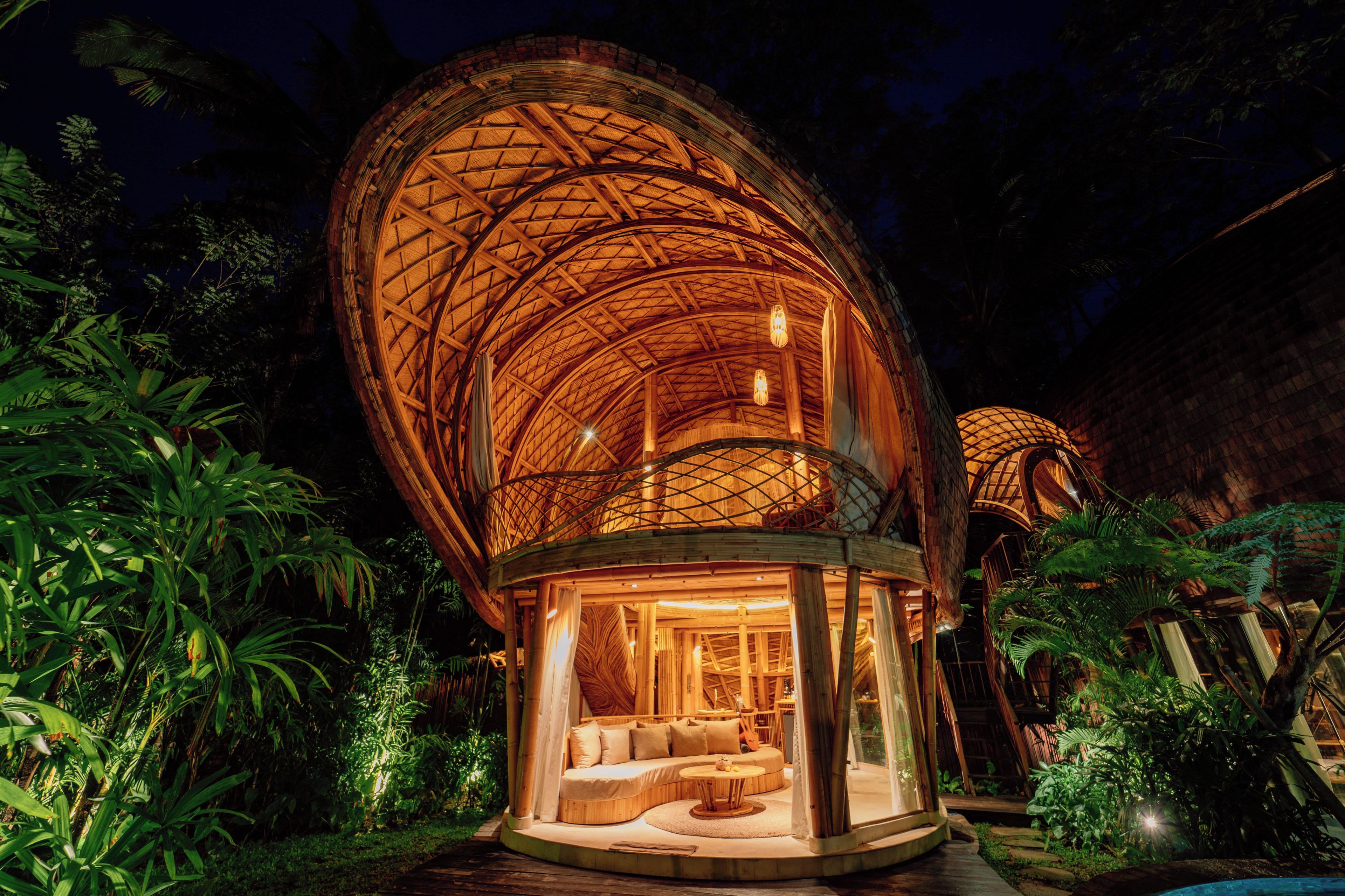Una estructura en forma de cúpula con un interior circular, un área de estar con cojines y una pequeña mesa.