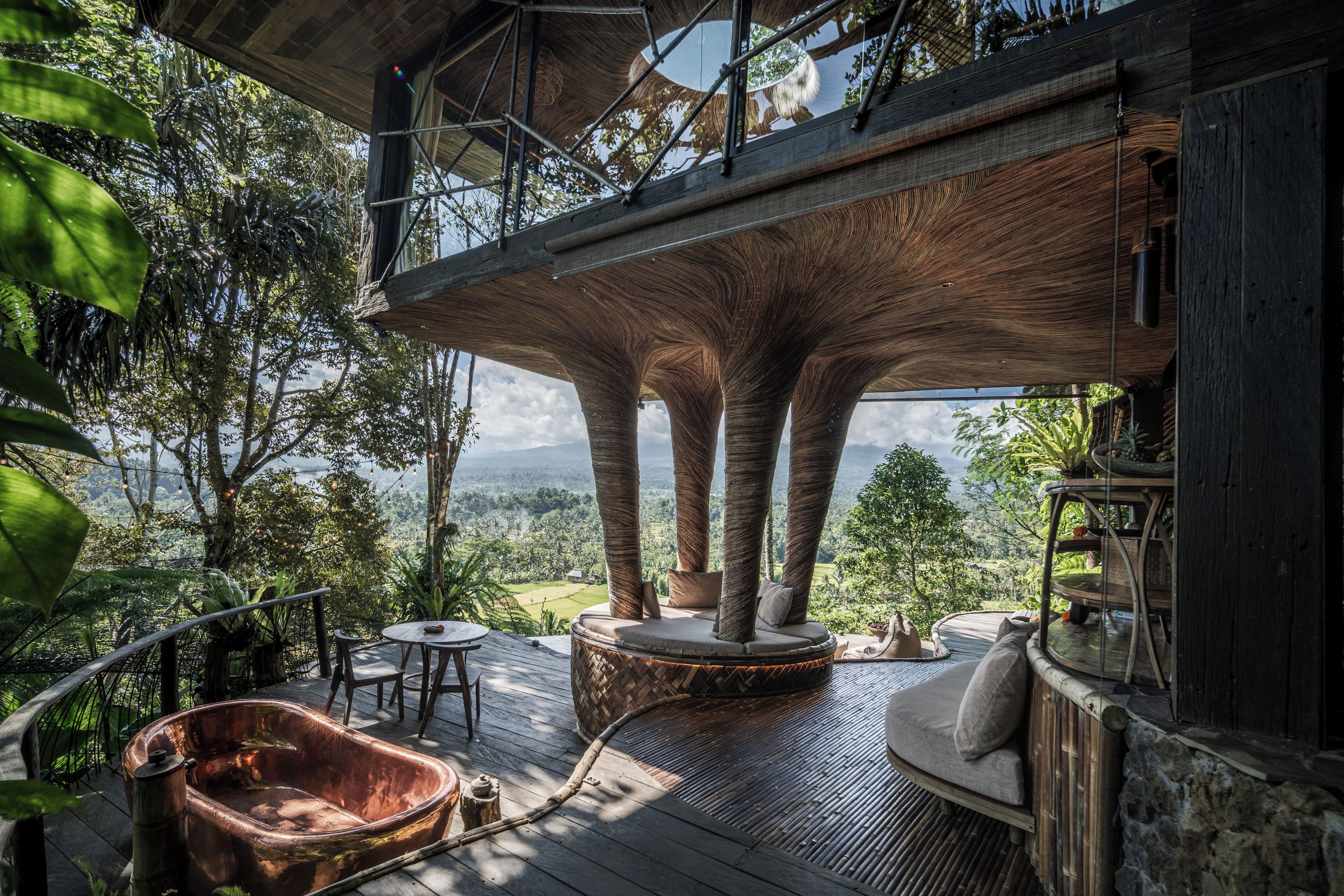 Um deck de madeira com hidromassagem, área de estar e vista para a paisagem.