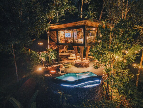 A treehouse with a pool, surrounded by dense foliage. - Hideout Eco Bamboo House Bali (Selat)