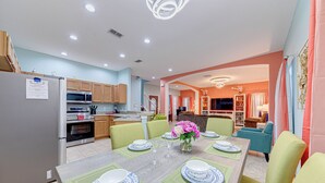 A modern kitchen with a dining area set for six. - Affordable Luxury 4 BR Villa, Close to Disney & Orlando, Pool/Spa, Arcade Games. (Clermont)