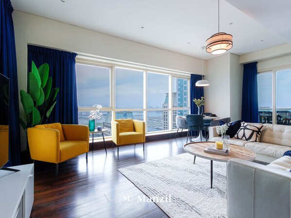 A modern living room with a view of the city skyline, a dining area, and a large window with curtains.