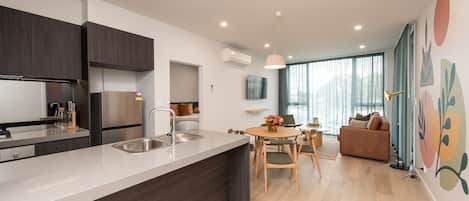 Apartamento luxo, 2 quartos | Cozinha privada | Geladeira, micro-ondas, cooktop, lava-louças