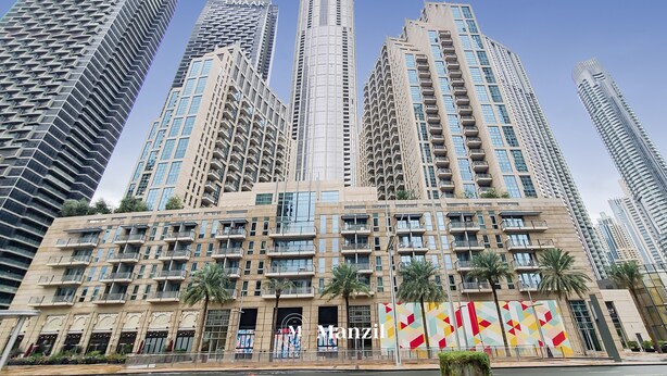 Un immeuble de grande hauteur doté de nombreux balcons et d’une tour imposante.