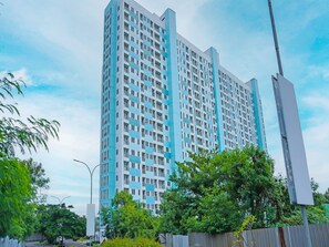 A high-rise building with a modern architectural design, featuring a grid of windows and balconies.