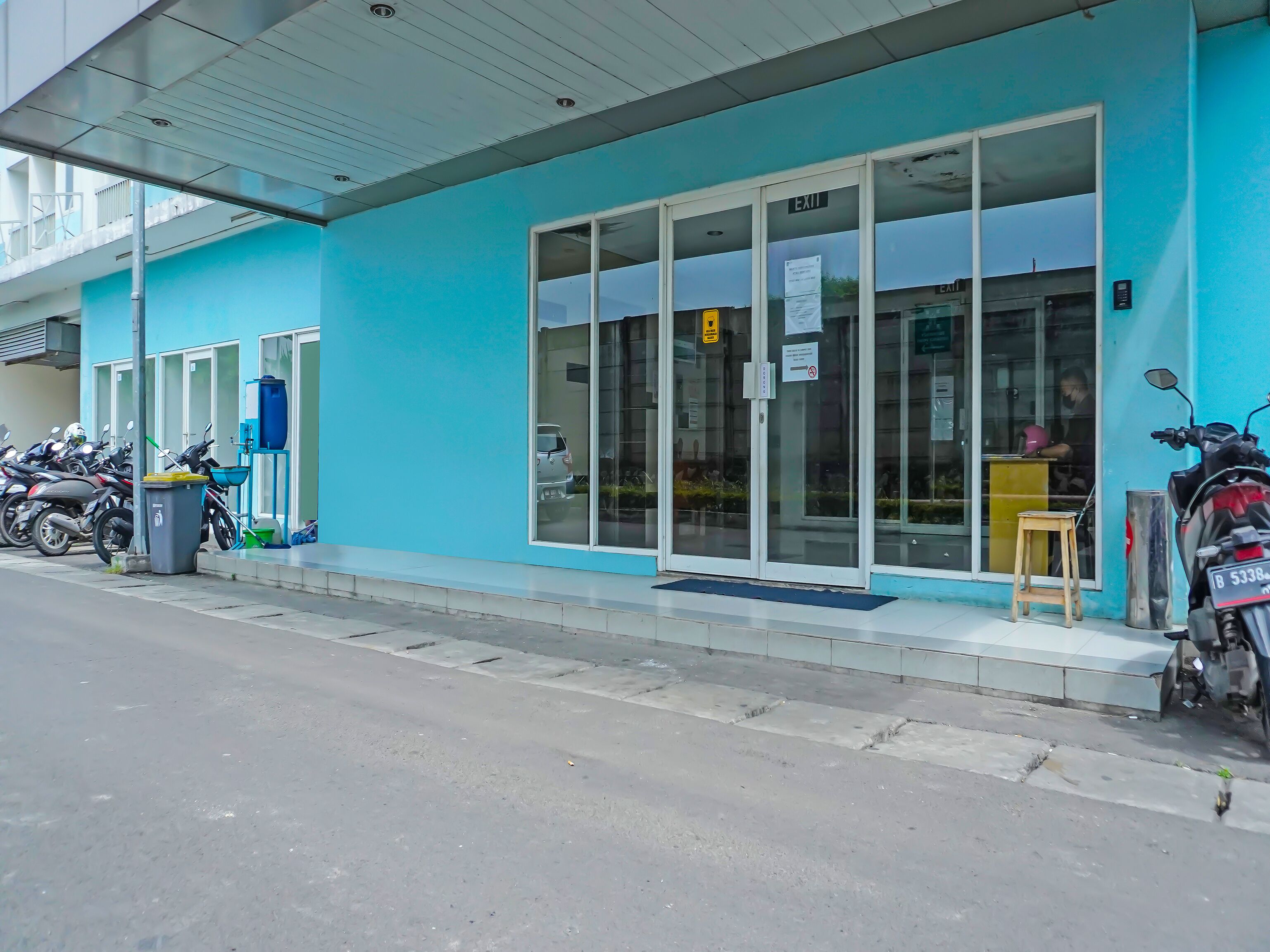 A building with a blue exterior, a glass door entrance, and a sign indicating an exit.