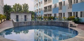 Un immeuble moderne doté d’une piscine et de balcons.