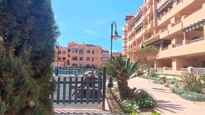 A residential building with balconies and a gated entrance. - Apartment in Almerimar with Pool & Beaches (Almeria)