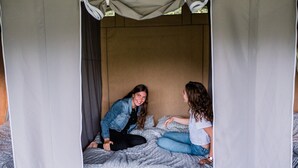 A bed with a canopy, a headboard, and a patterned bedspread.