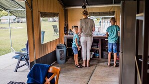 A kitchen area with a counter, a trash bin, and a refrigerator.