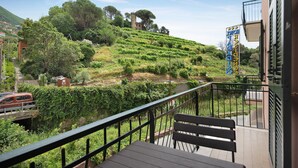 Un balcon donnant sur un vignoble, un banc et une enseigne indiquant le nom de l’hôtel.