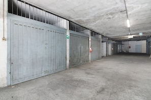 A large industrial-style building with metal doors, a concrete floor, and a visible exit sign.