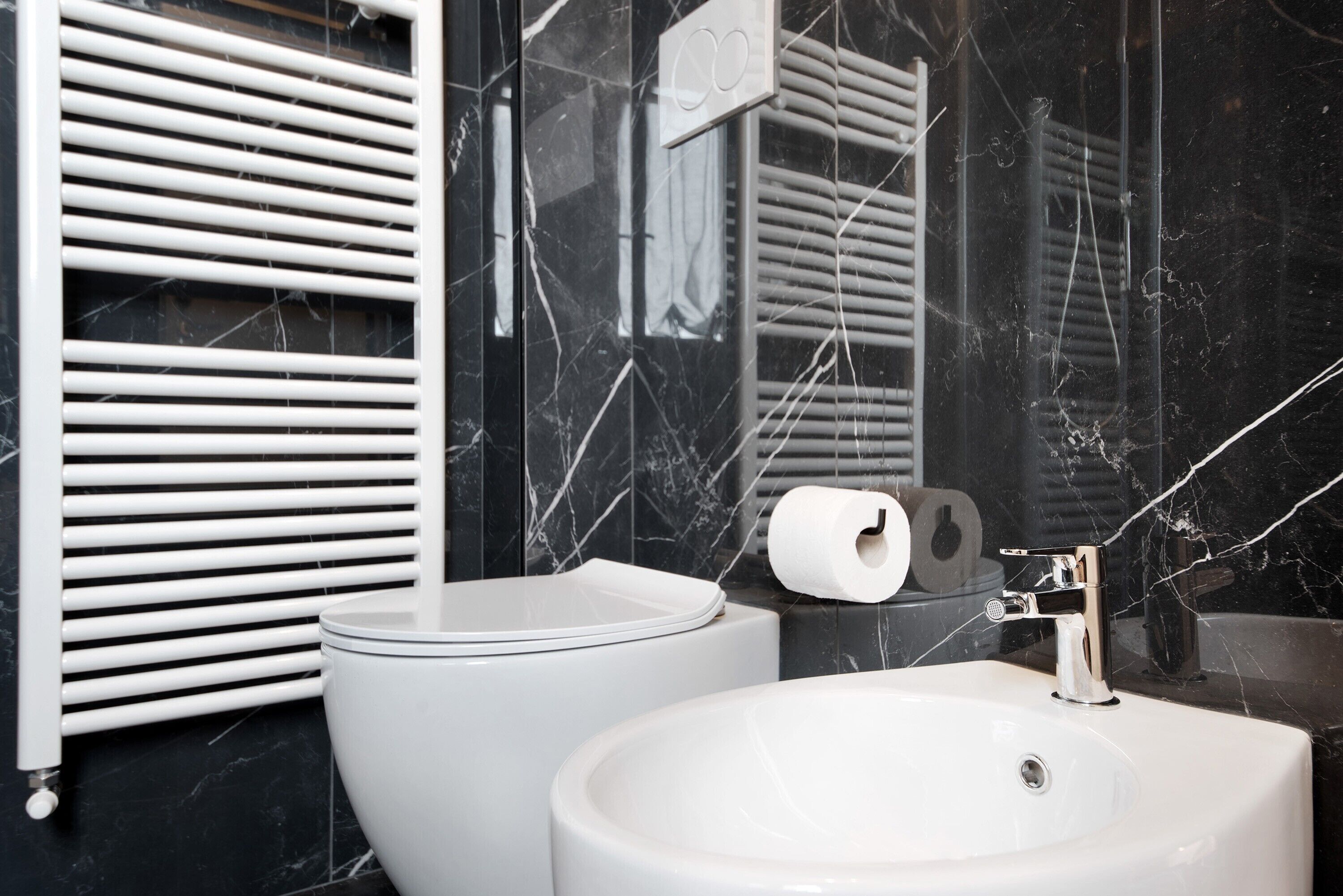 Ein Badezimmer mit Toilette, Waschbecken und Handtuchspender.