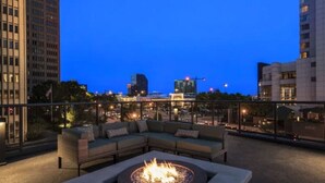 A rooftop terrace with a fire pit, seating area, and city views at dusk. - The Heart of the city (Atlanta)