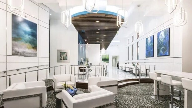 A modern hotel lobby with white sofas, a reception desk, and artwork on the walls. - The Heart of the city (Atlanta)