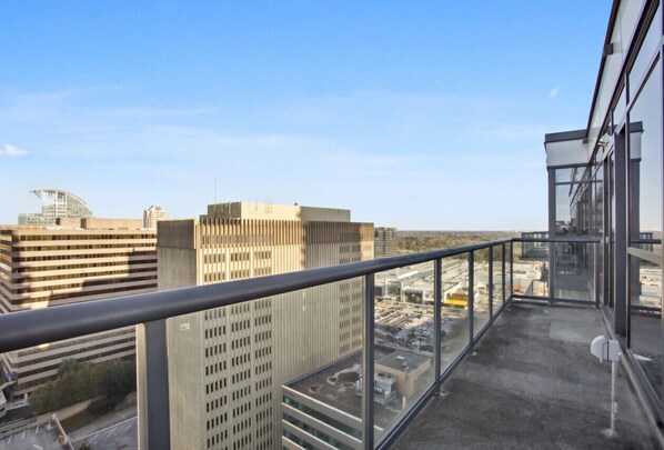 A high-rise building with a glass balcony overlooking a cityscape.