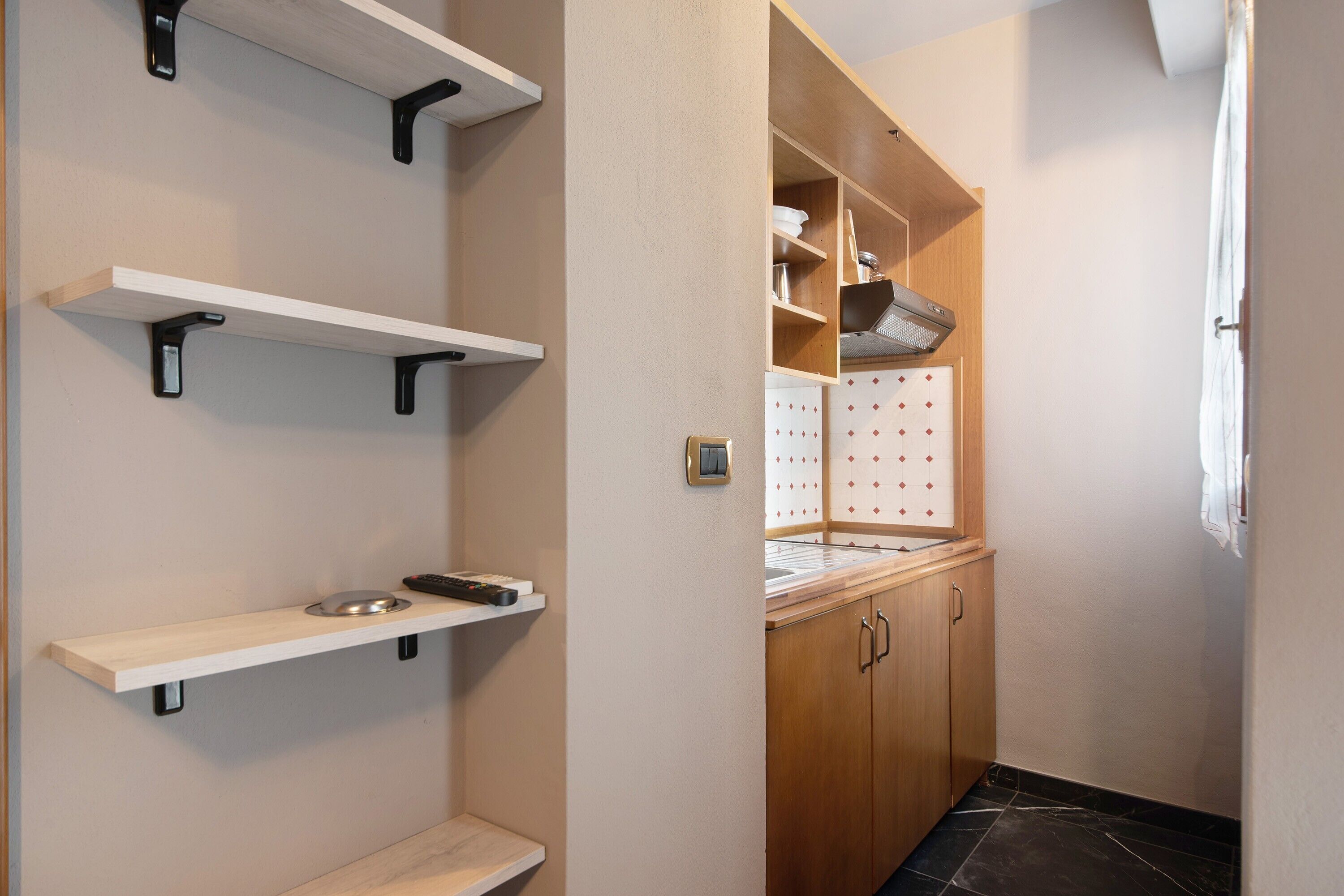 Een keuken met houten kastjes, een aanrecht en een spatwand.