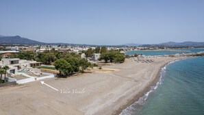 Une zone côtière avec une plage, des villas et un ciel dégagé.