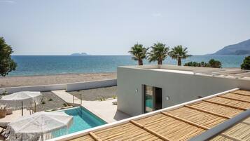 Een buitenzwembad, ligstoelen bij het zwembad