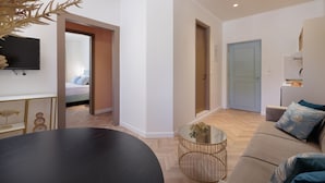 Un salon moderne avec un canapé, une table basse et un téléviseur fixé au mur.