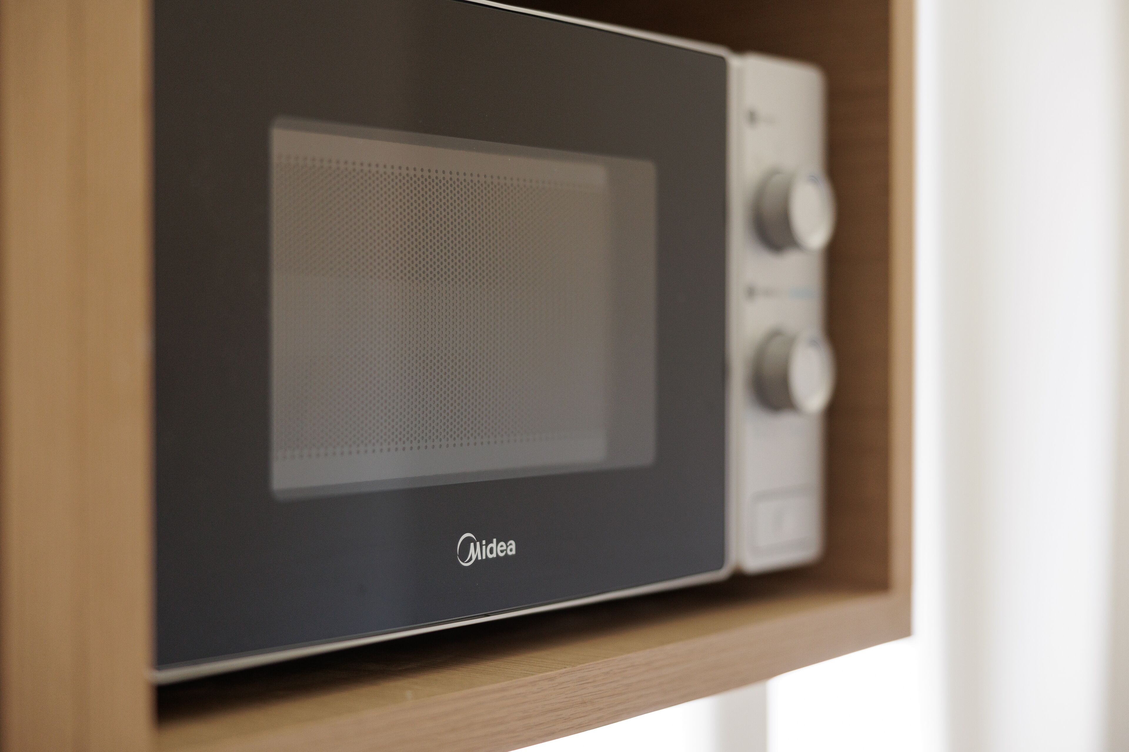 A microwave oven with a control panel and a brand name visible.