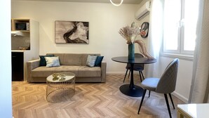 Un salon moderne avec un canapé, une table basse et un coin repas.
