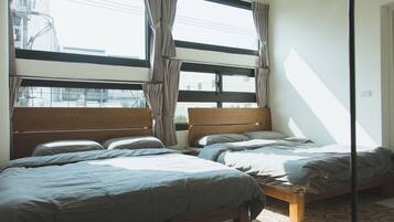 Un dormitorio con dos camas, ventanas amplias y vistas a la ciudad.