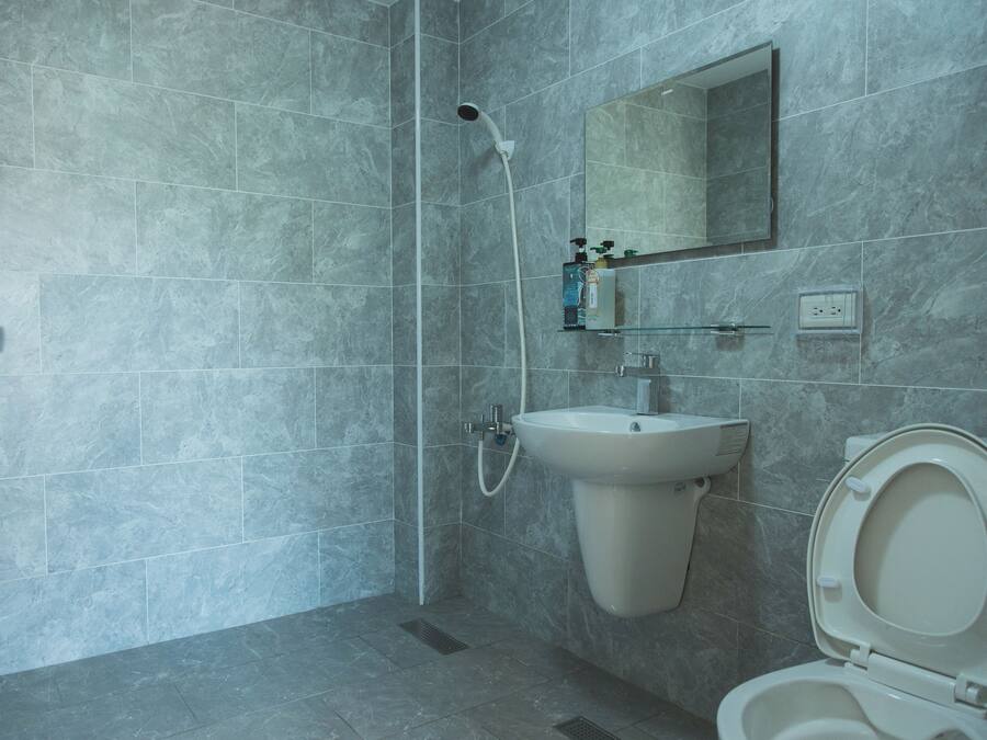 A modern bathroom with a shower, sink, and toilet.