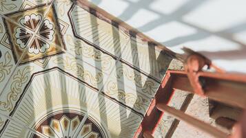 A spiral staircase with ornate tile patterns and a metal railing.
