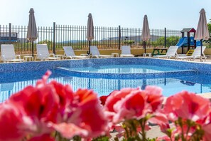 Seasonal outdoor pool, open 9:00 AM to 9:00 PM, pool umbrellas