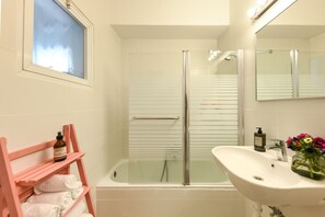Appartement | Badkamer | Een bad/douchecombinatie, gratis toiletartikelen, zeep, shampoo