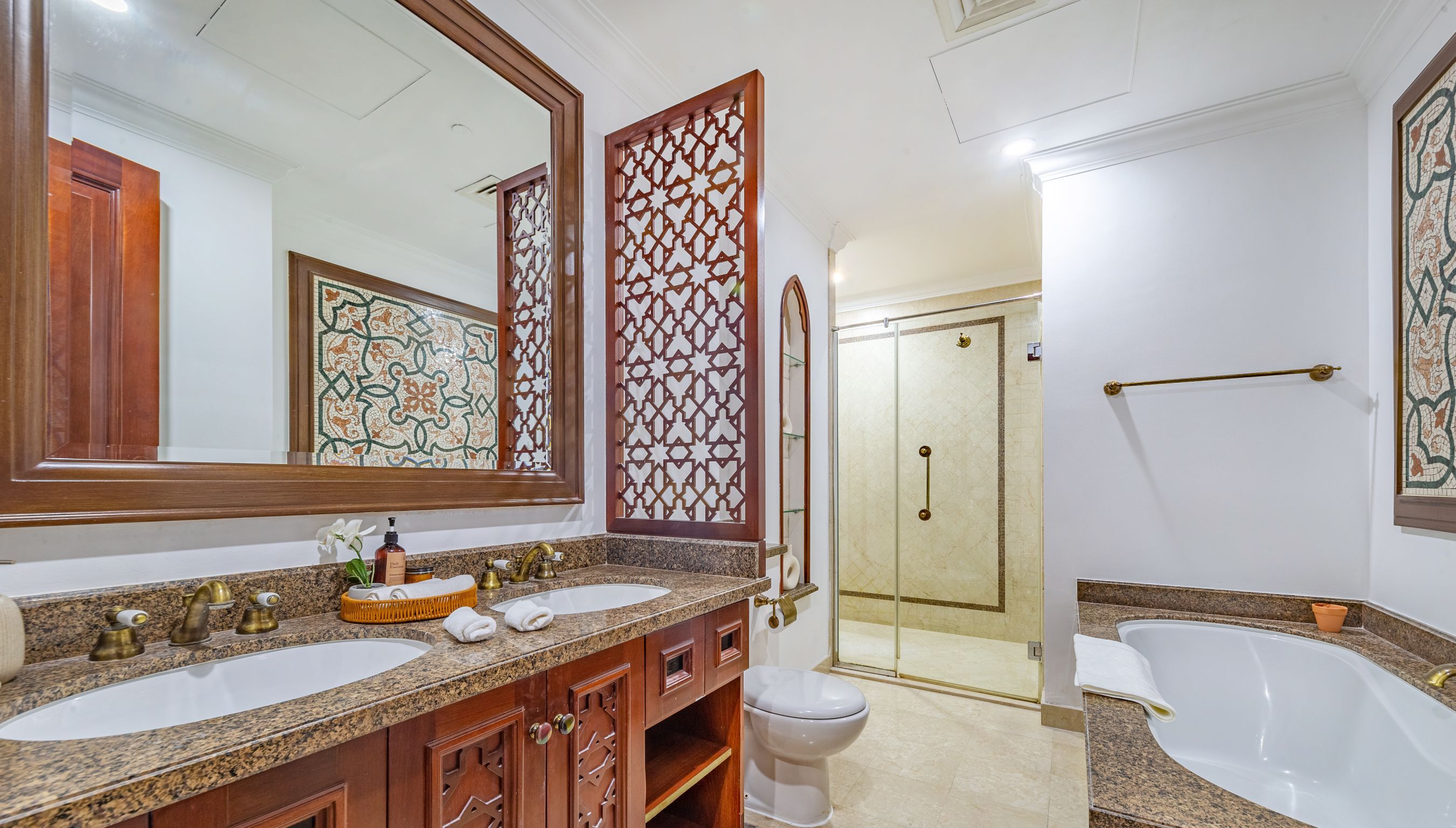 A bathroom with two sinks, a toilet, a shower, and a bathtub.