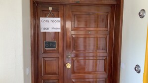 A wooden door with a sign indicating a 'Cozy room near Metro' and a chalkboard sign stating '6 Fte'. - Cozy room near Metro Station, close to  Airport  , easy access to city center (Lisboa)