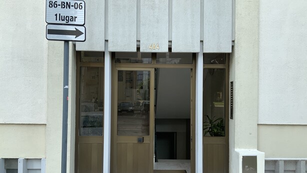 A building entrance with a sign indicating a location and a wheelchair accessibility symbol. - Cozy room near Metro Station, close to  Airport  , easy access to city center (Lisboa)