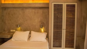A bedroom with a bed, two bedside lamps, a nightstand, and a wardrobe with a woven design. - Stavlos Cottage - Apartment Ground Floor 1 (Lefkada)