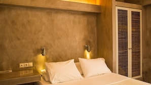 A bedroom with a bed, two wall-mounted light fixtures, a bedside table, and a wardrobe with a glass door. - Stavlos Cottage - Apartment Ground Floor 1 (Lefkada)