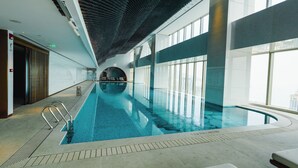 An indoor swimming pool with clear water, large windows, and a modern architectural design. - MGM Qingdao (Qingdao)