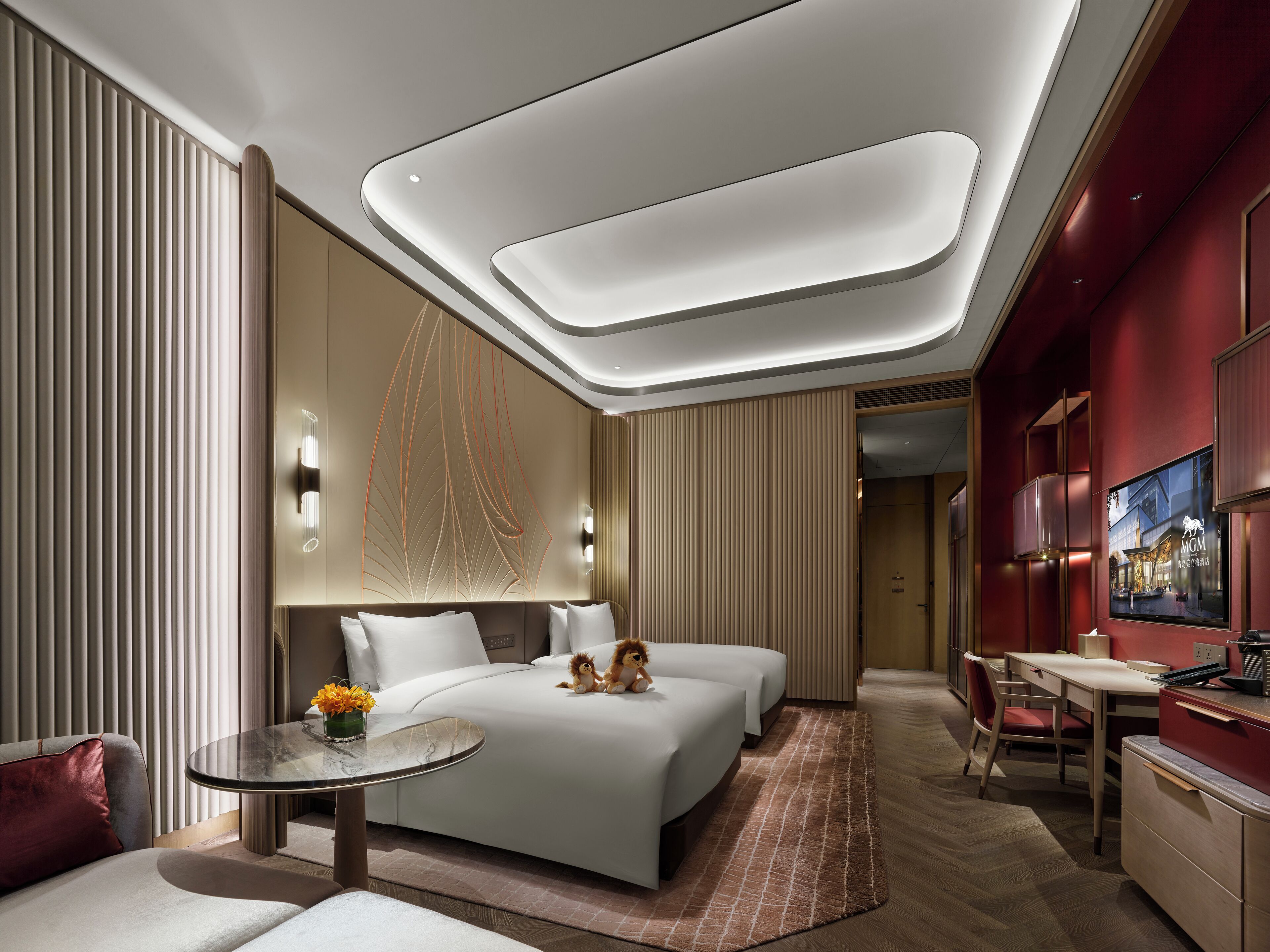 A modern hotel room with a large bed, a desk, and a seating area.