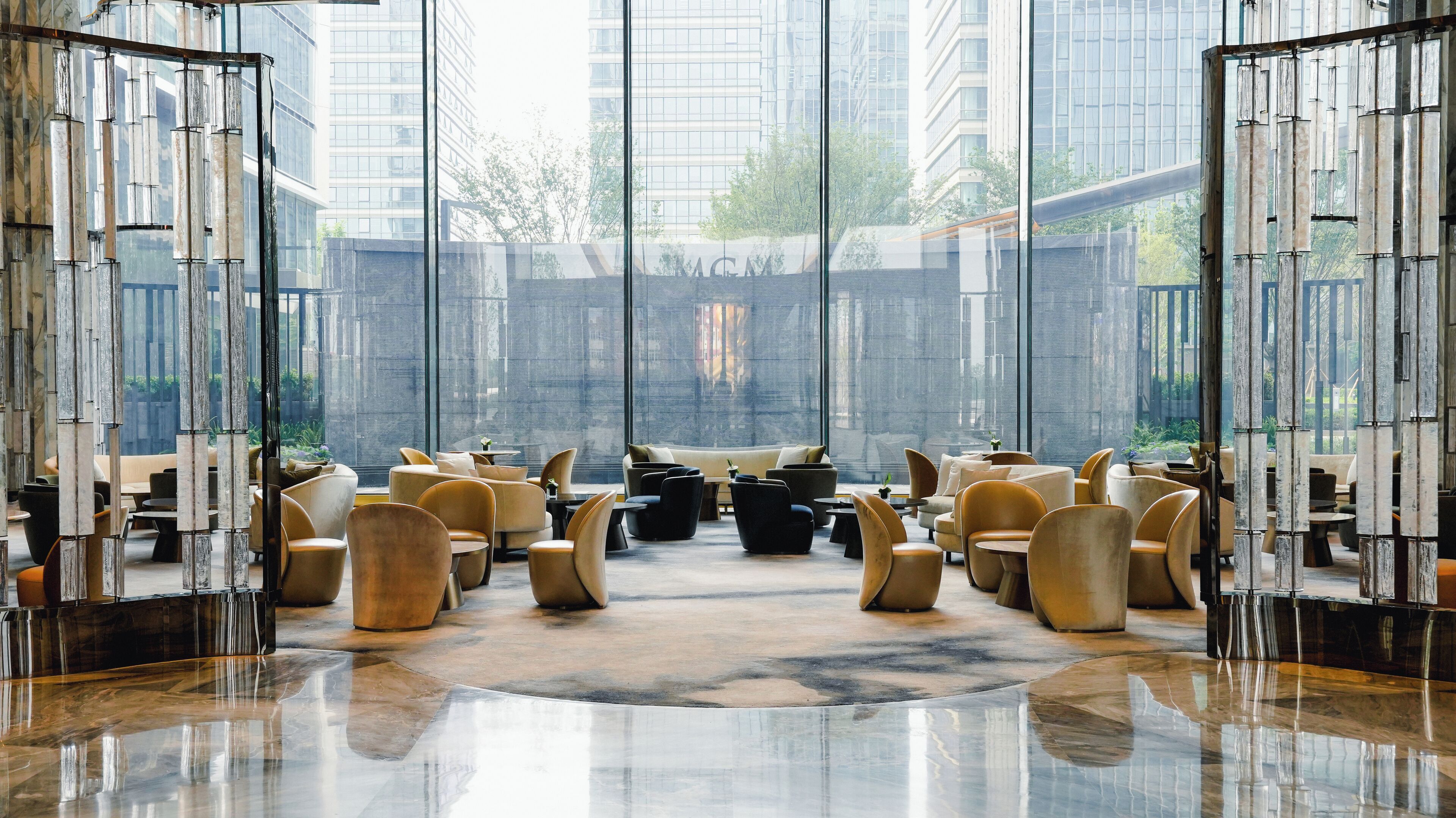 A spacious lobby with modern furniture, large windows, and a polished floor.
