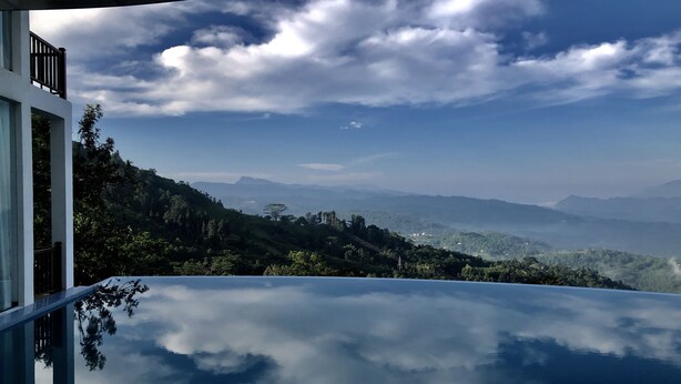Vista panorámica desde un balcón, cielo despejado y montañas a lo lejos.