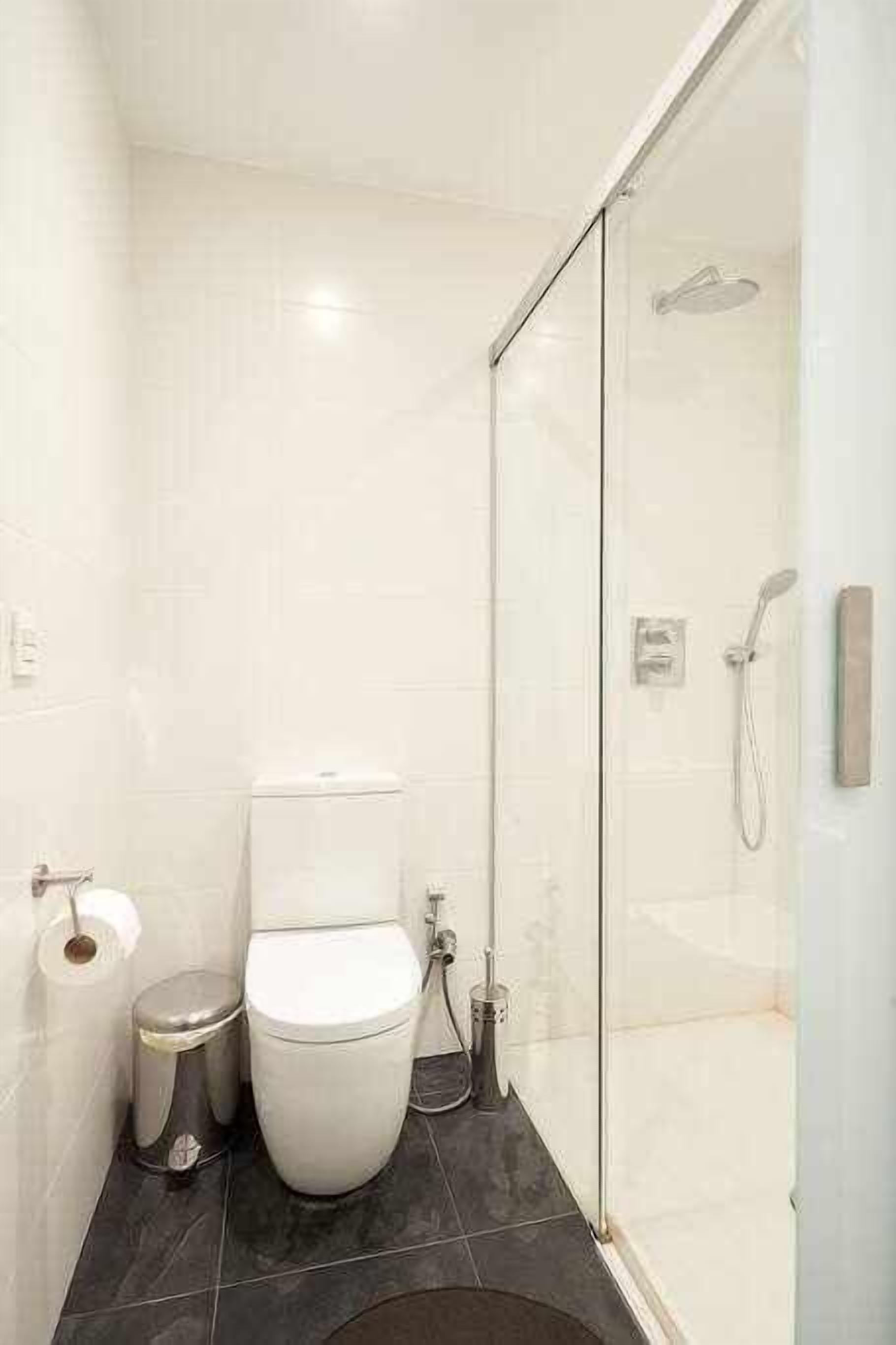 Un bagno moderno con WC, bidet e cabina doccia in vetro.